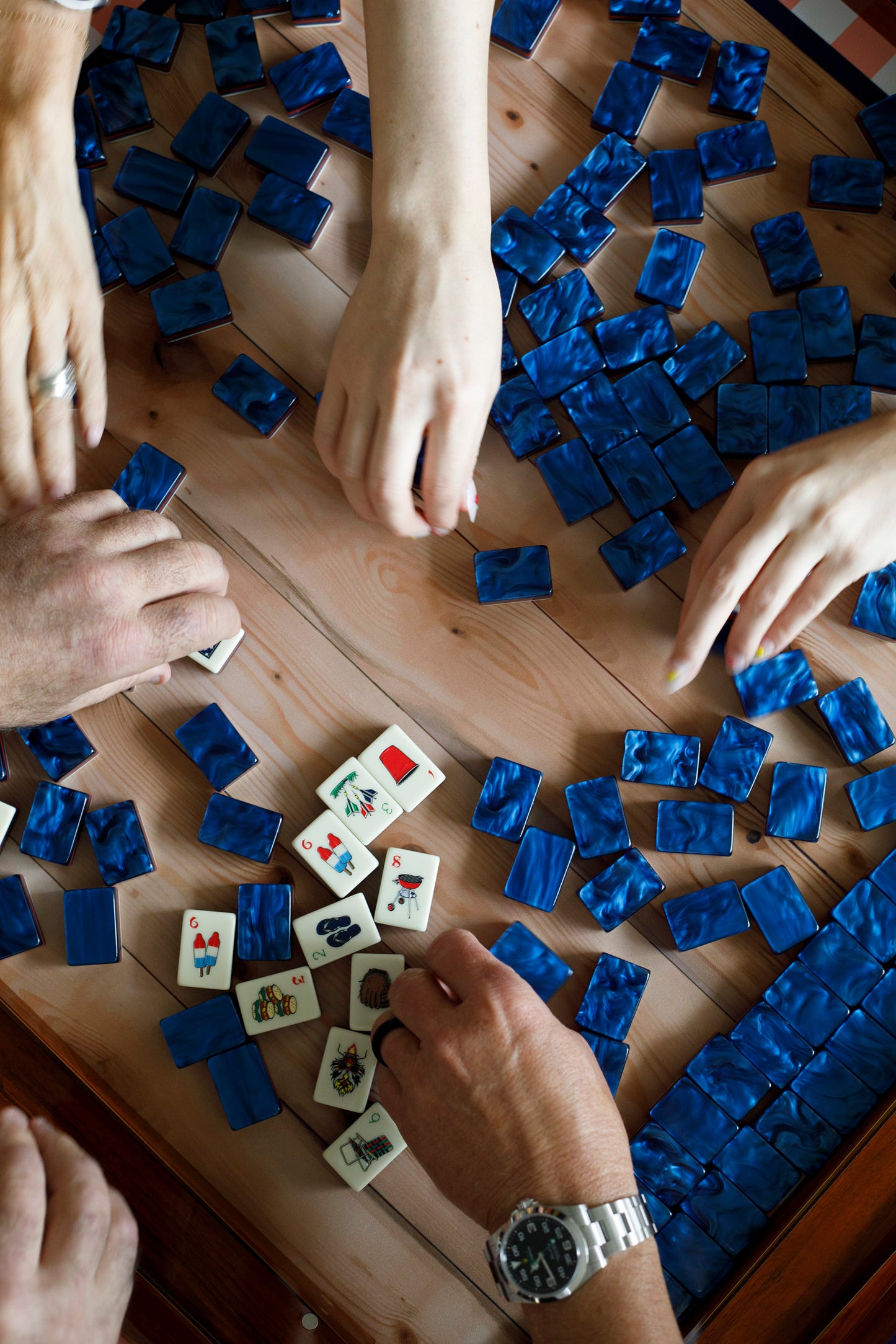 Mahjong tiles full pille, people grabbing tiles