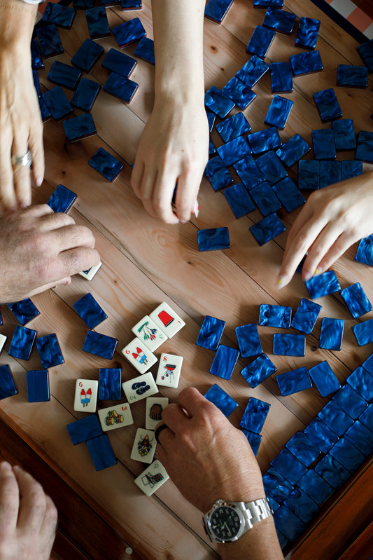 Mahjong tiles full pille, people grabbing tiles